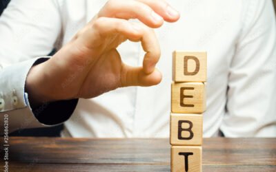 Businessman removes wooden blocks with the word Debt. Reduction or restructuring of debt. Bankruptcy announcement. Refusal to pay debts or loans and invalidate them. Debts service relief